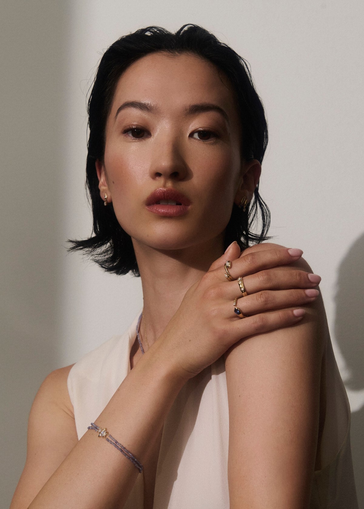 Alt="Vale Jewelry Rainfall Triple Marquise Moonstone & Beaded Tanzanite Bracelet worn on model with hand placed on her shoulder and white bacckground"