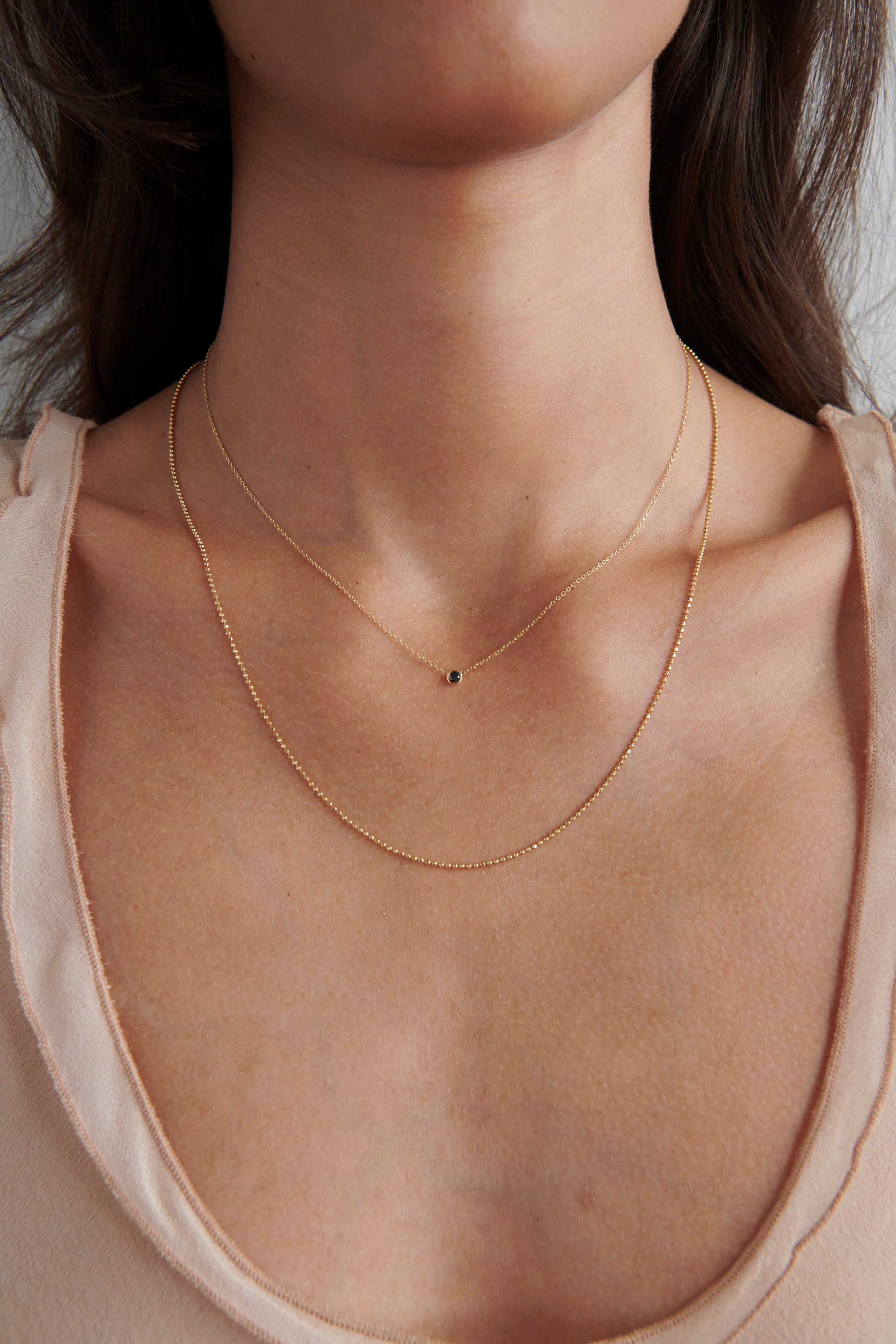 Model Wearing Vale Jewelry Barely-There Black Diamond Necklace Layered with Faceted Bead Chain Necklace