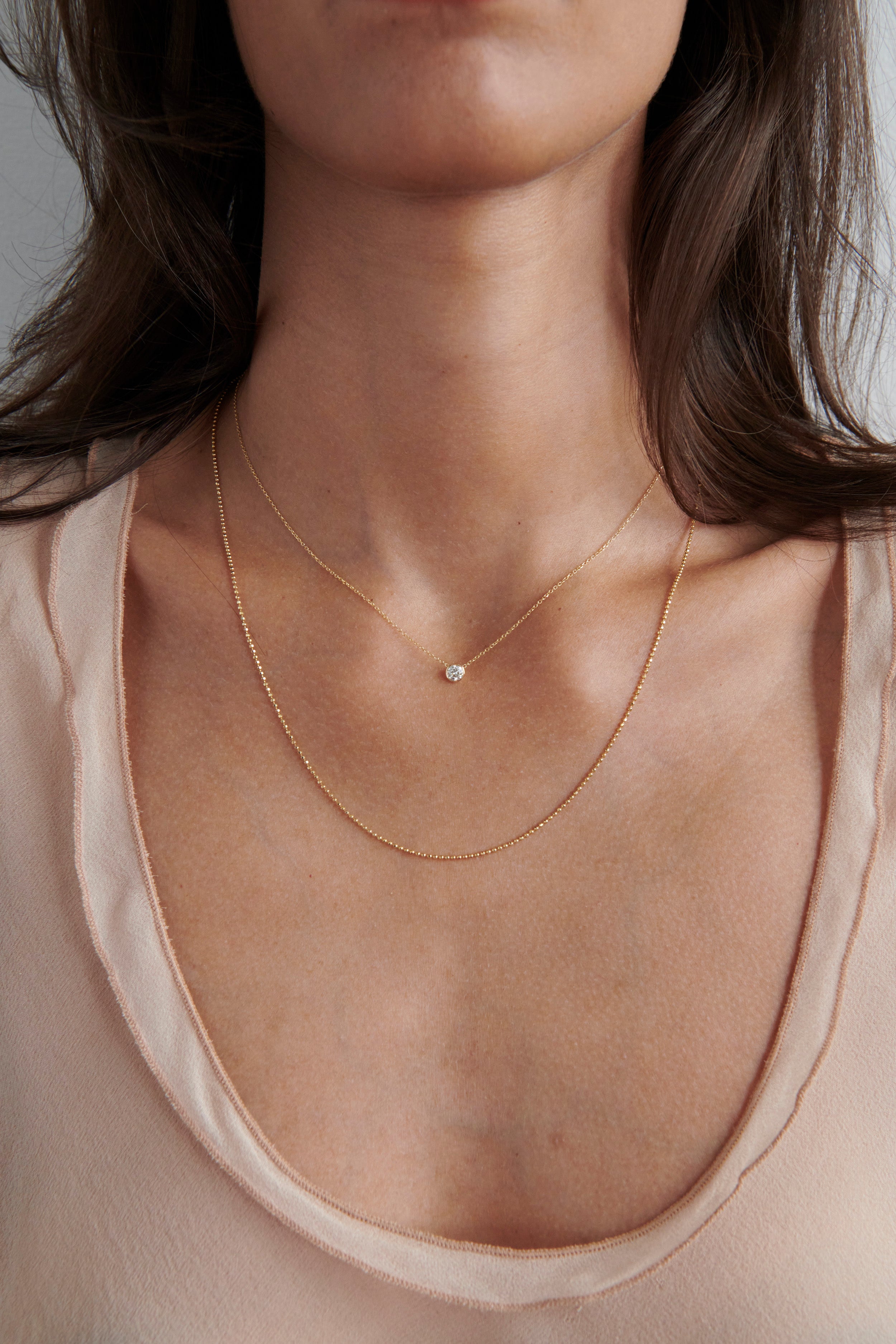 Model Wearing Vale Jewelry Barely There-Medium Diamond Necklace Layered with Faceted Bead Chain Necklace