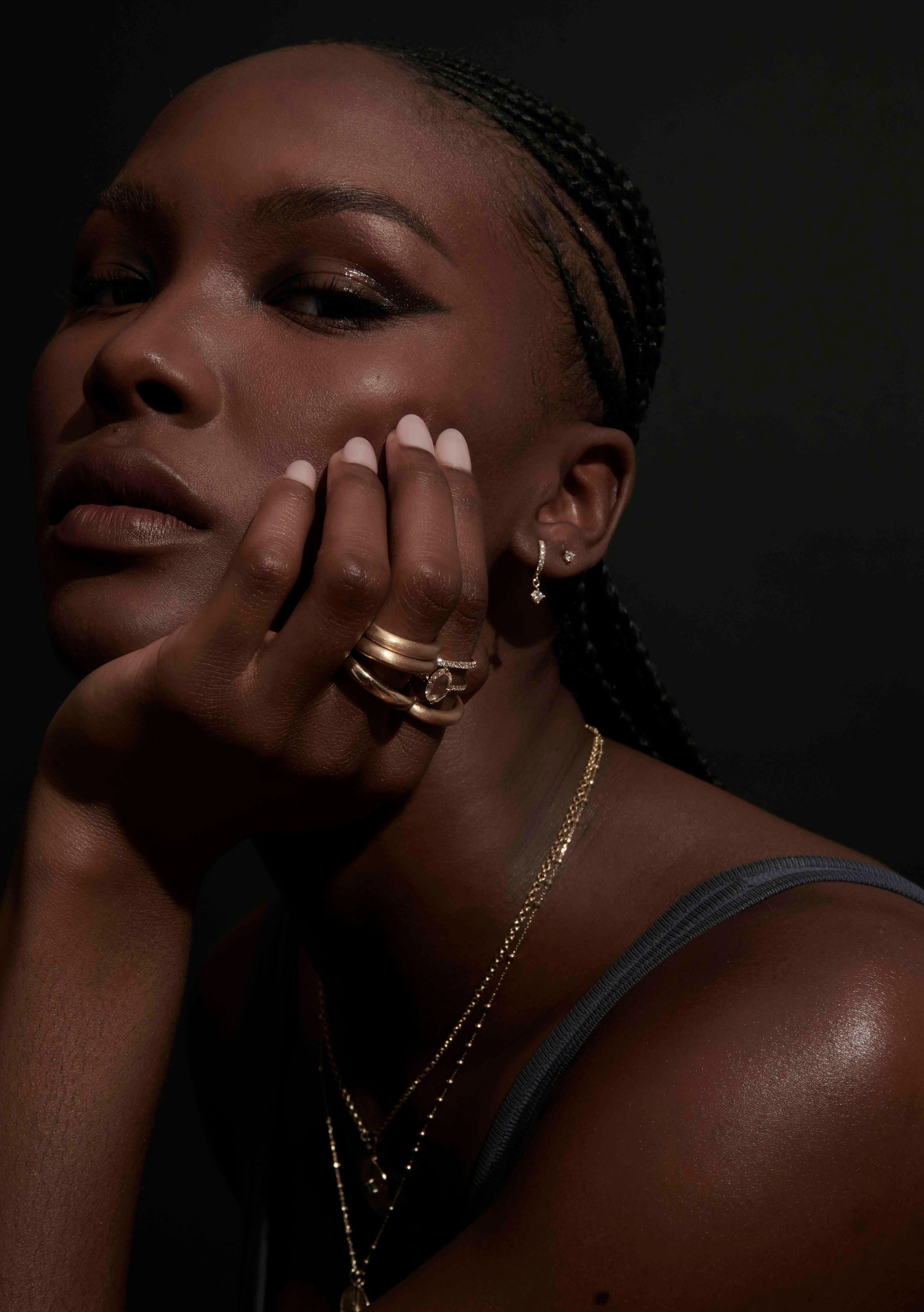 Model wearing pieces from Vale Jewelry, including stacked Barrel Rings in Yellow Gold