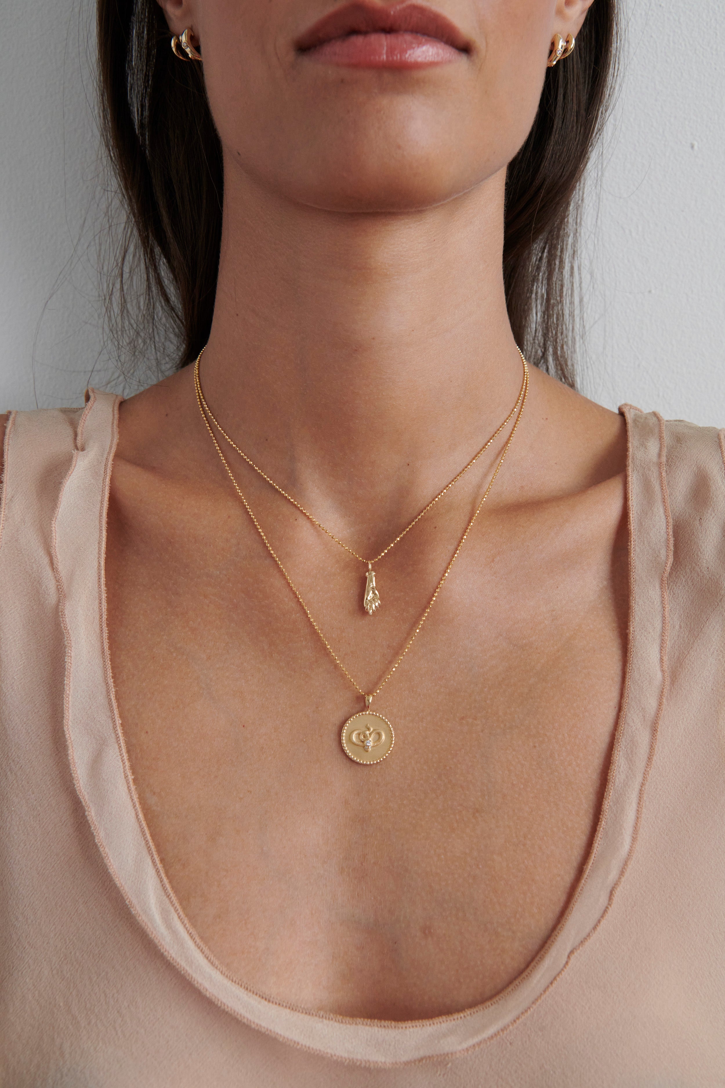Close-up of Model Wearing Vale Jewelry Figa Amulet Necklace with Serpent Disc Pendant with Diamonds