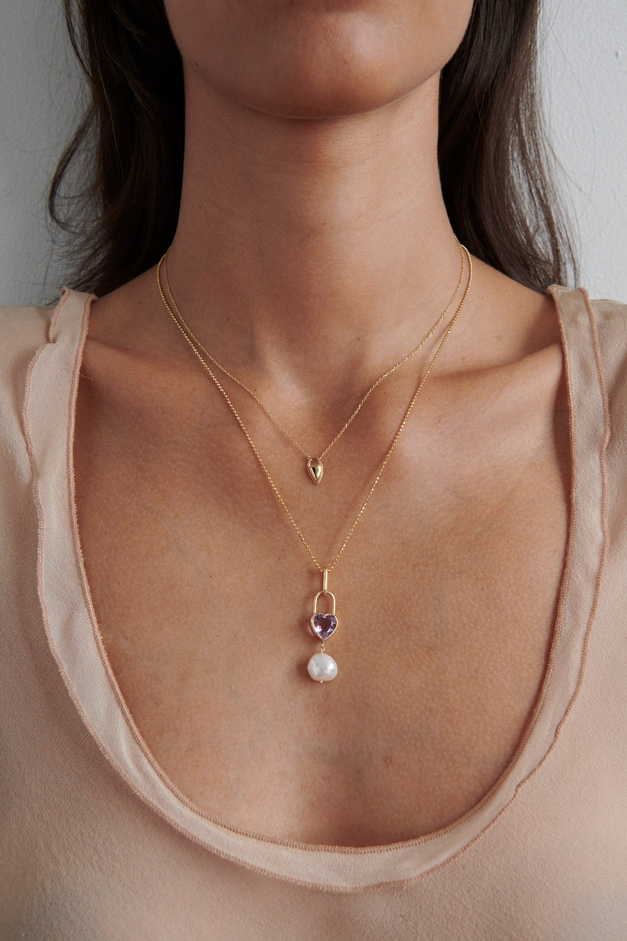 Close-up of Model Wearing Vale Jewelry Large Heart Lock and Baroque Pearl Necklace