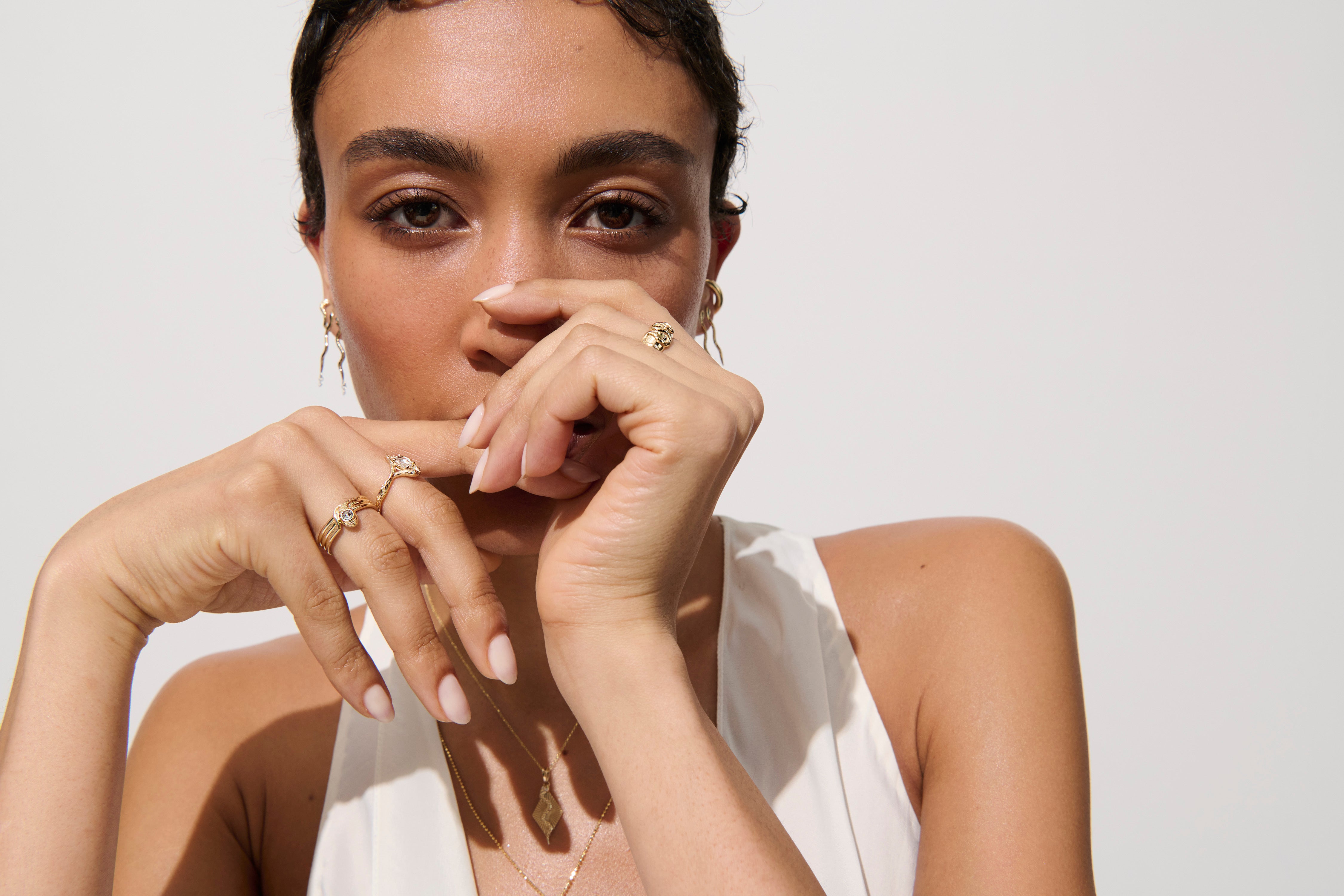 Alt="Vale Jewelry model wearing serpent ring with hands in front of face"