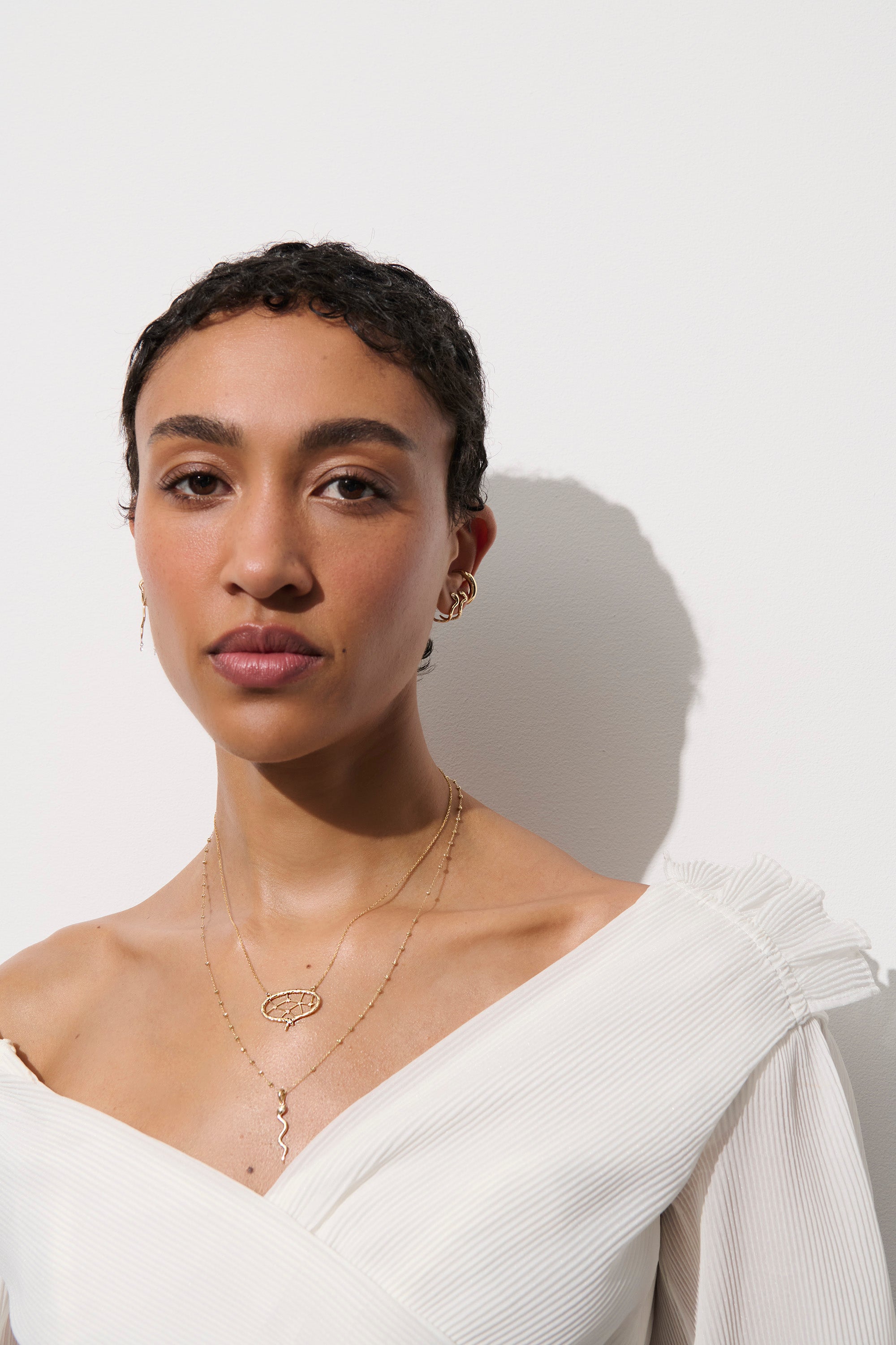 Model wearing eb of stars and serpent necklace in a white top