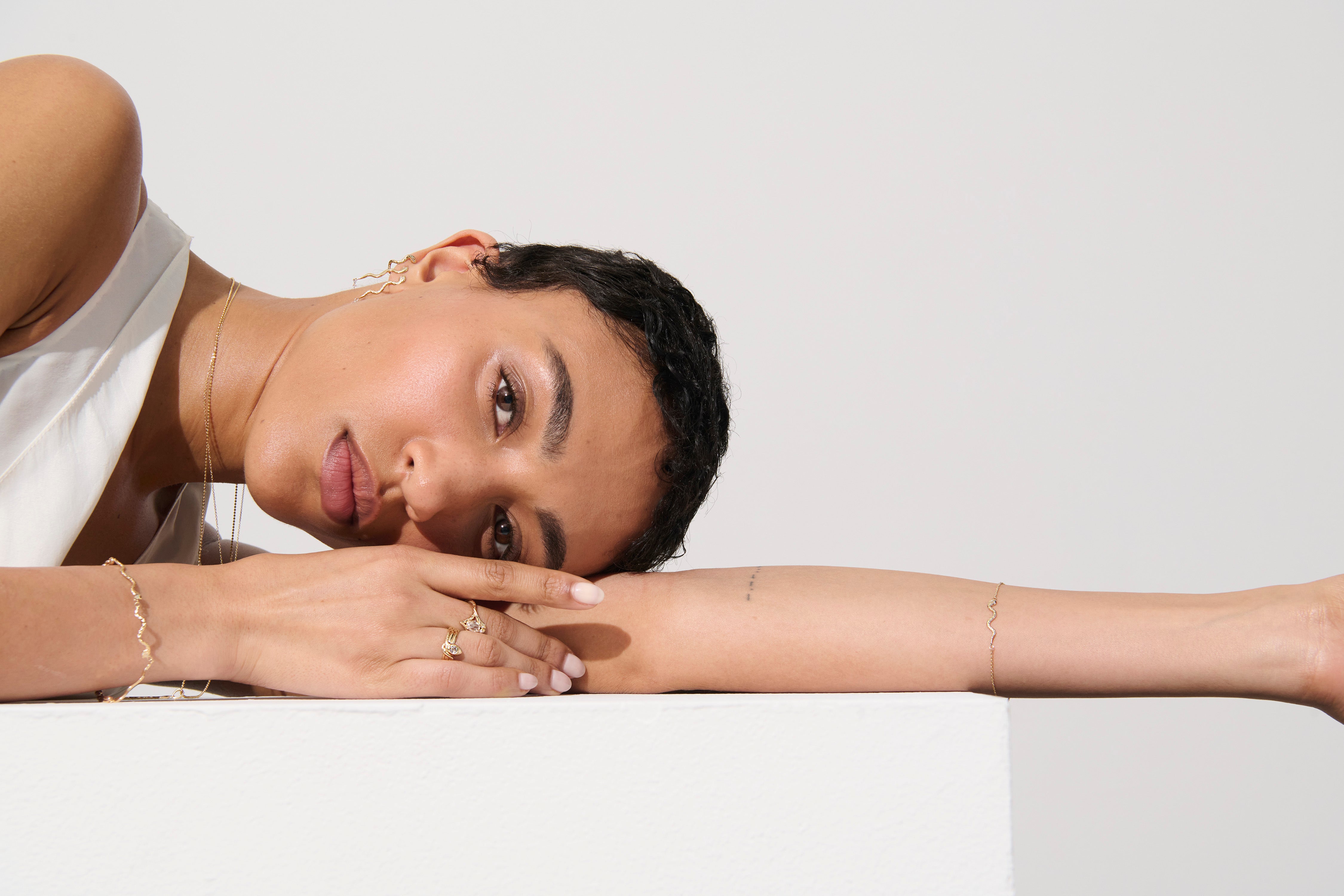 Alt="Vale Jewelry model wearing textured serpents bracelet while laying down facing the camera"