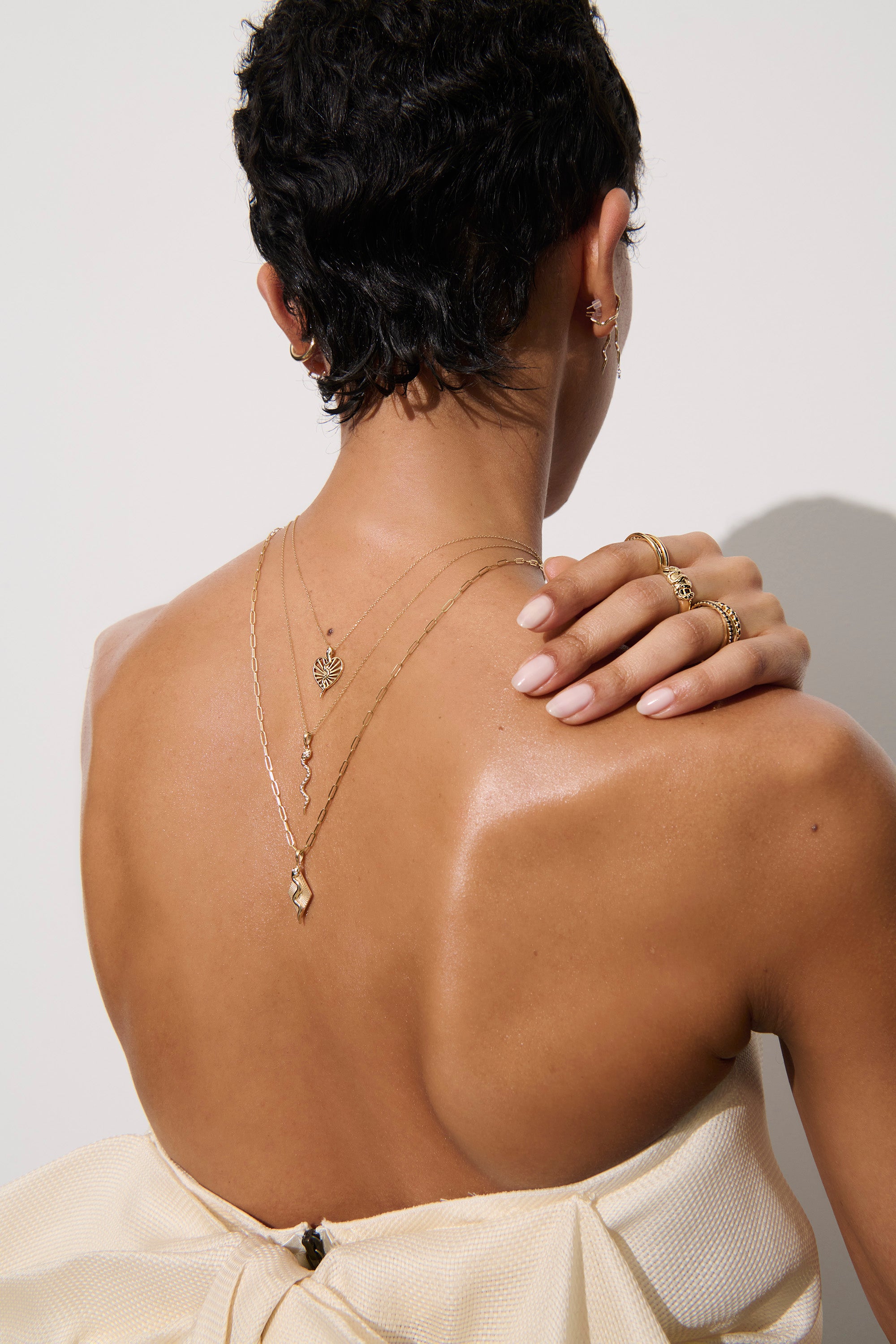 Alt="Vale Jewelry Model facing away from the camera with textured serpent necklace and serpent ray necklace on backwards"