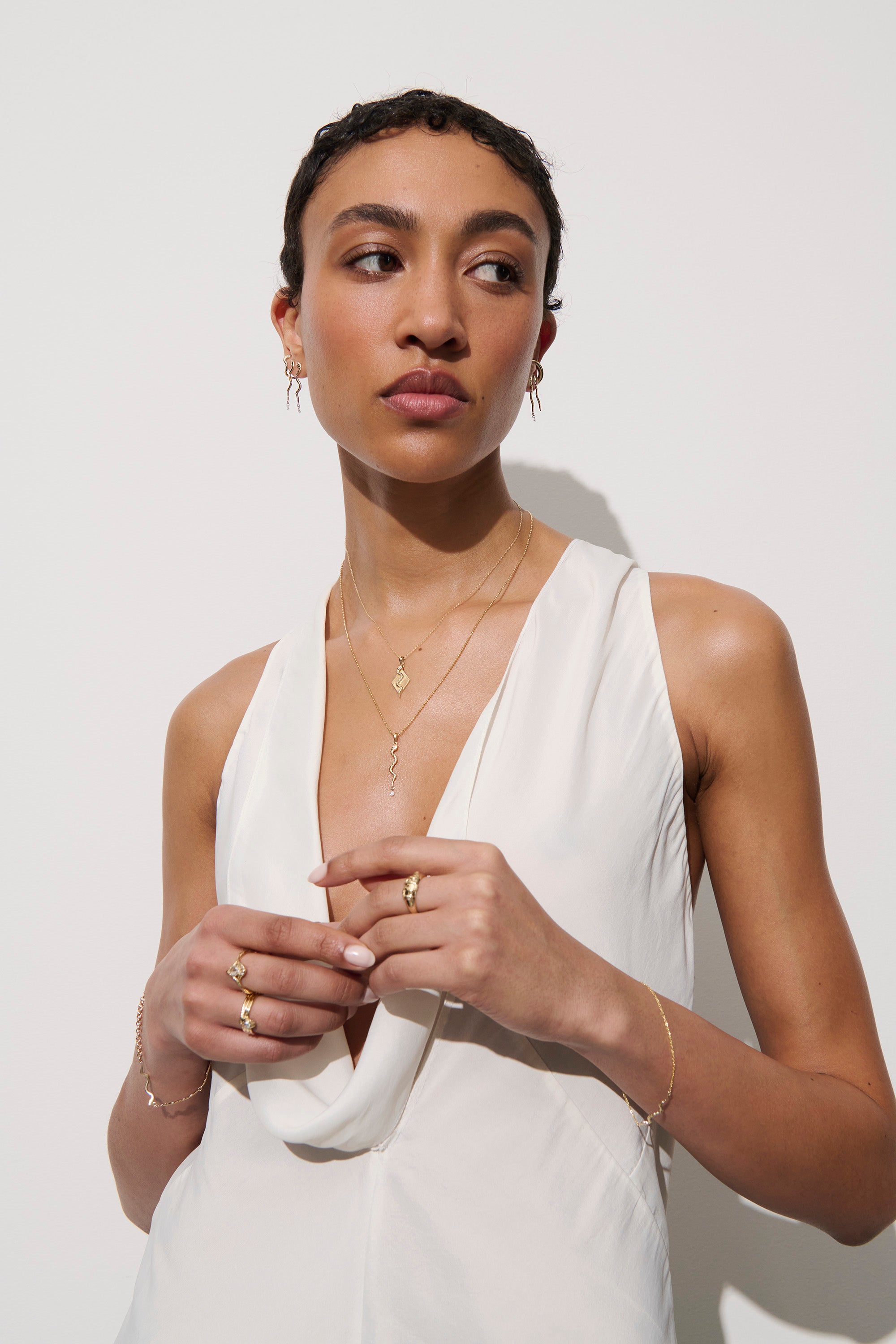 Alt="Vale Jewelry Model wearing serpent earrings with diamond drops, textured serpent necklace with diamond necklace, textured ray necklace"