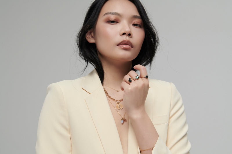 Model wearing many sapphire rings, including the Lune ring with sapphire