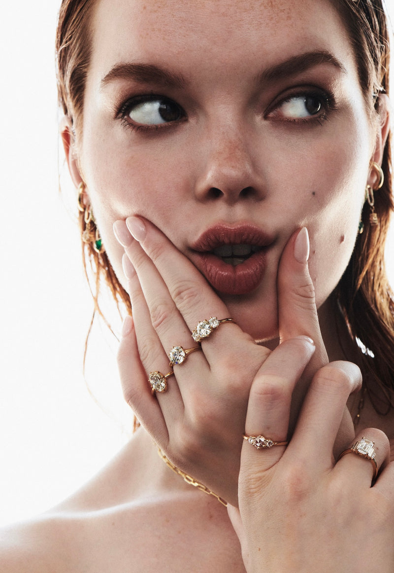 Close up of Model with Hand on Face Modeling 3 Diamond Rings Including 2.06 Carat Collet Set Ring, 2.09 Carat Old Mine Delilah Ring and 3-Stone Old Mine Ring from Vale Jewelry