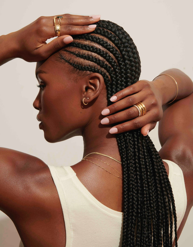 Model Wearing Wide Star Set Dome Ring and Thin Gold Quotiden Bangle with Stack of Chunky Gold Rings from Vale Jewelry