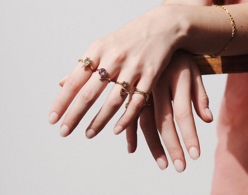 Model's Hands Modeling 4 Rings from Vale Jewelry Including Amethyst Octagon and Diamond Twist Lock Ring, Toi et Moi Champagne Diamond Twist Ring and OOAK 1.50 Carat Step Cut Pear Solitaire Diamond Ring