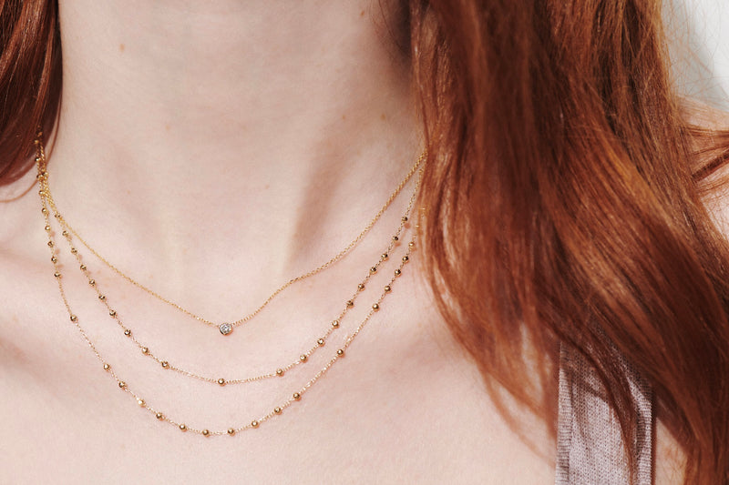 Close-up of Model Wearing Barely There Diamond Necklace with Two Rosary Necklaces Layered from Vale Jewelry