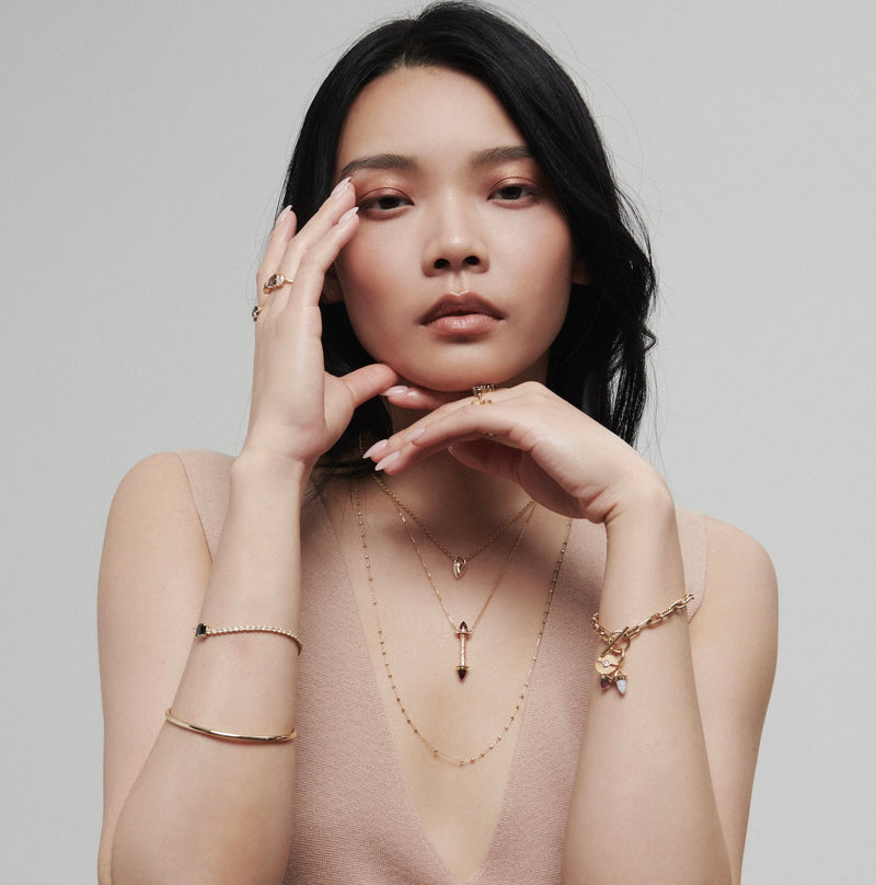 Model Wearing Layers of Gold Necklaces with Heavy Quotidien Bangle from Vale Jewelry