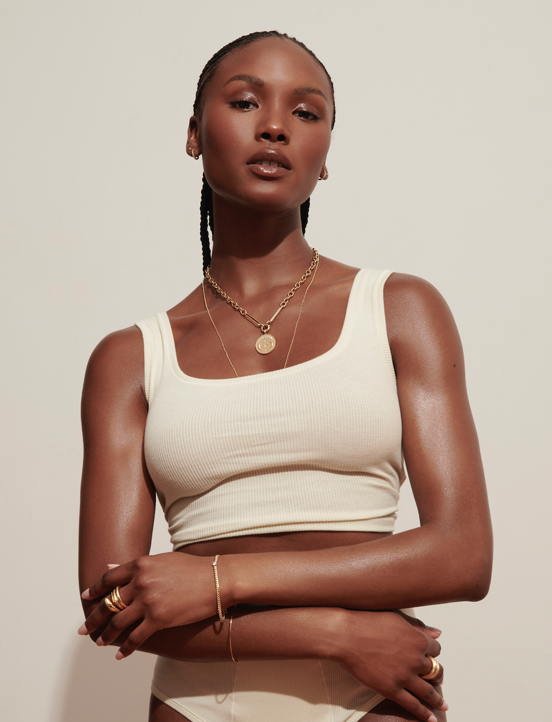 Model Wearing Gold Disc Evelyne Necklace with Chunky Chain and Curb Marnie Bracelet with Stacked Gold Bands from Vale Jewelry