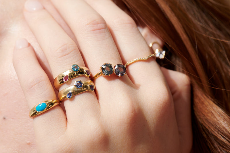 Up close of Model's Hand Wearing Vale Jewelry Mixed Shape Blue Sapphire Dome Ring and Mixed Shaped Multi-Stone Dome Band, Toi et Moi Spinel Ring, Tommy Ring with Turquoise, and Vesper Ring