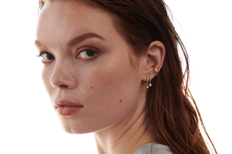 Model Wearing Pavé Huggie Earrings with Princess Cut Diamond Charms, Pavé Huggie Earrings with Round Diamond Charms and Rounded Ear Cuff from Vale Jewelry