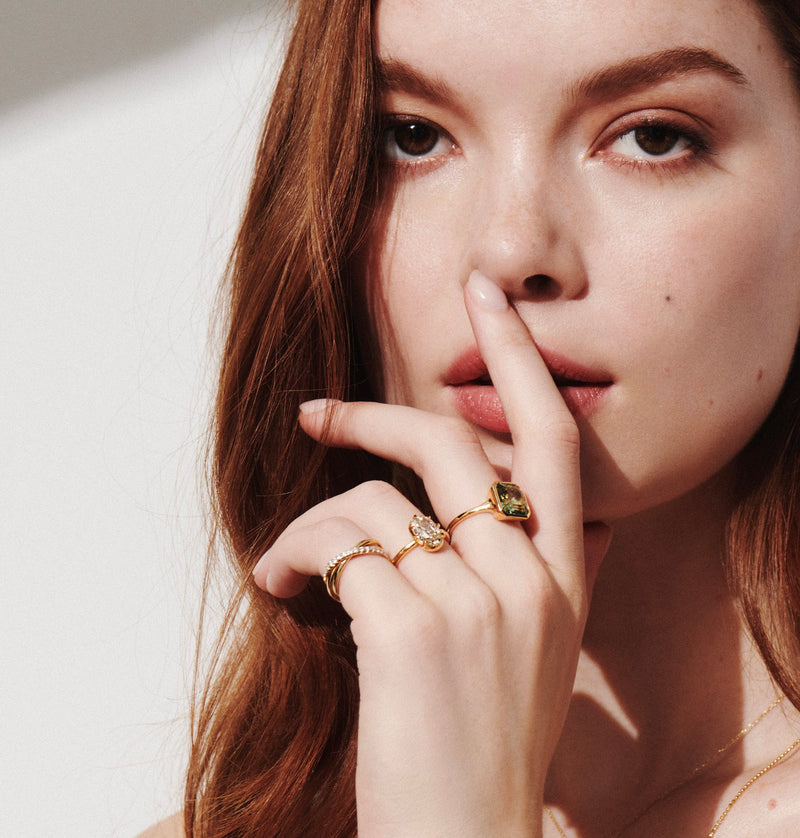 Model Wearing Sintra Rolling Ring with White Diamonds with One-of-a-kind Rings Including Asscher Cut Green Tourmaline Ring and Collet-Set Oval Diamond Ring from Vale Jewelry