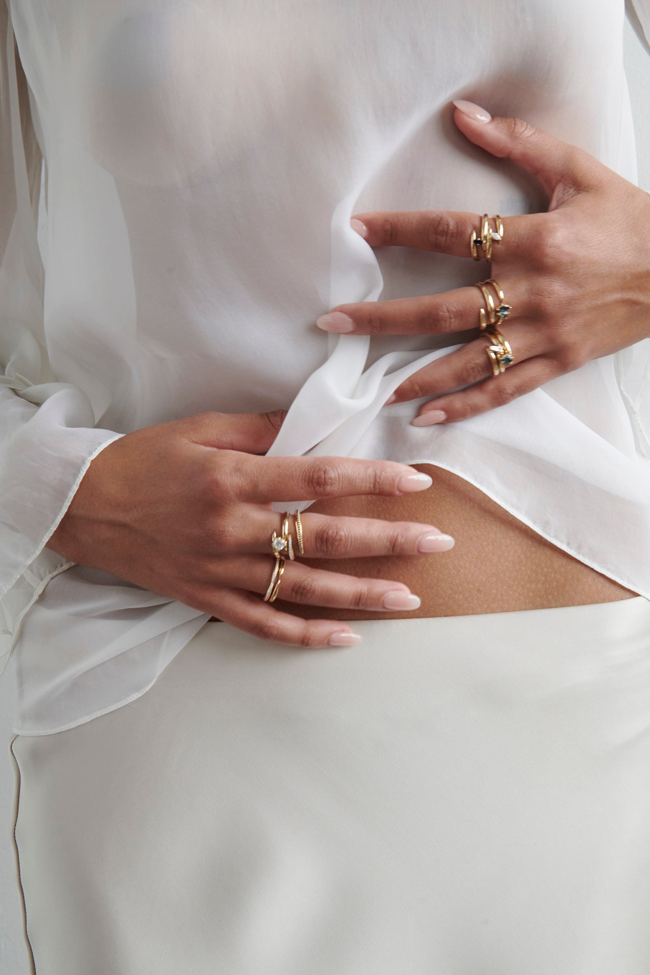 Close-up of Hand Model Wearing Vale Jewelry Swoop Marquise Cut Diamond Bypass Ring with Multiple Rings