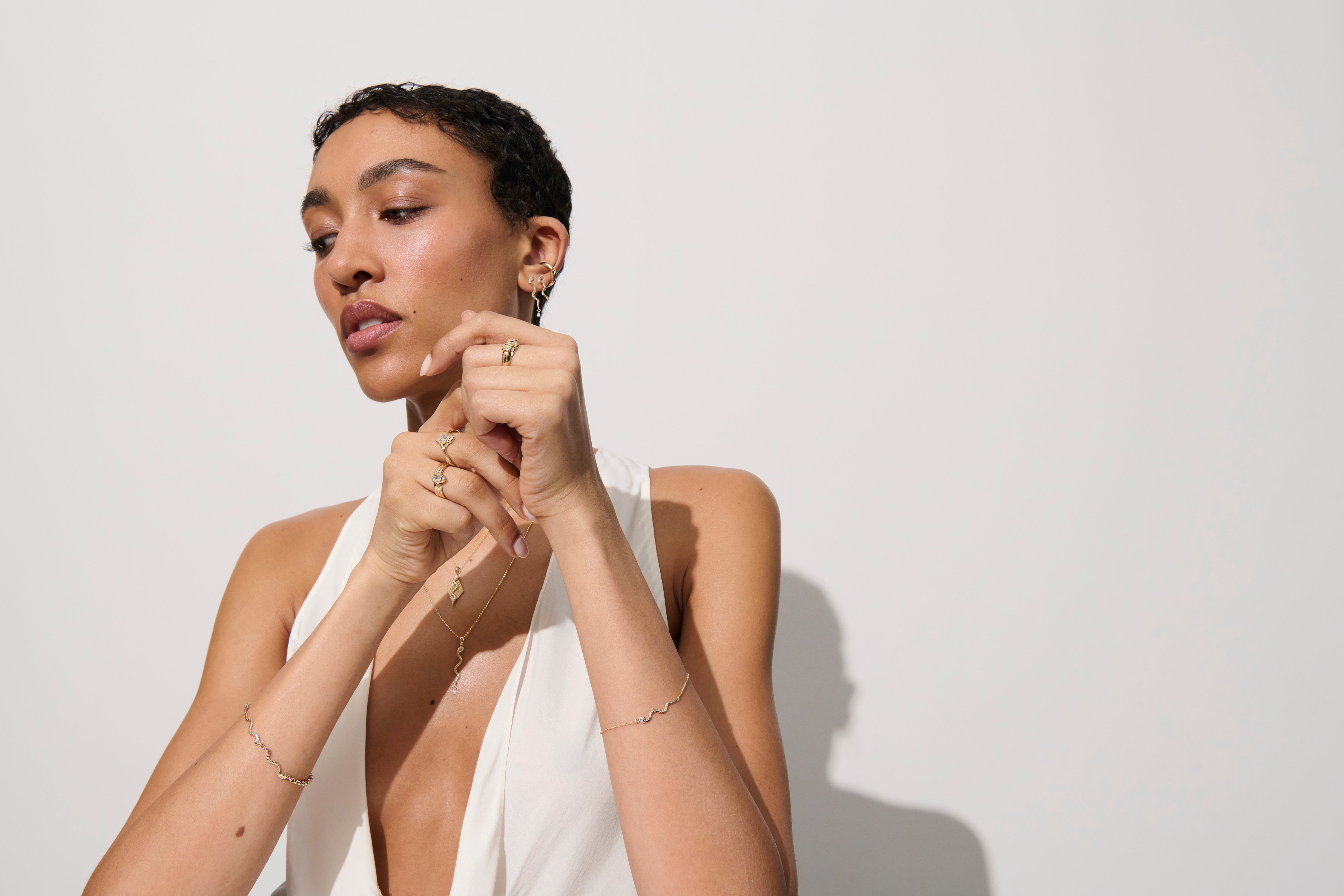 Alt="Vale Jewelry model shot with textured serpents bracelet, model is wearing other jewelry"