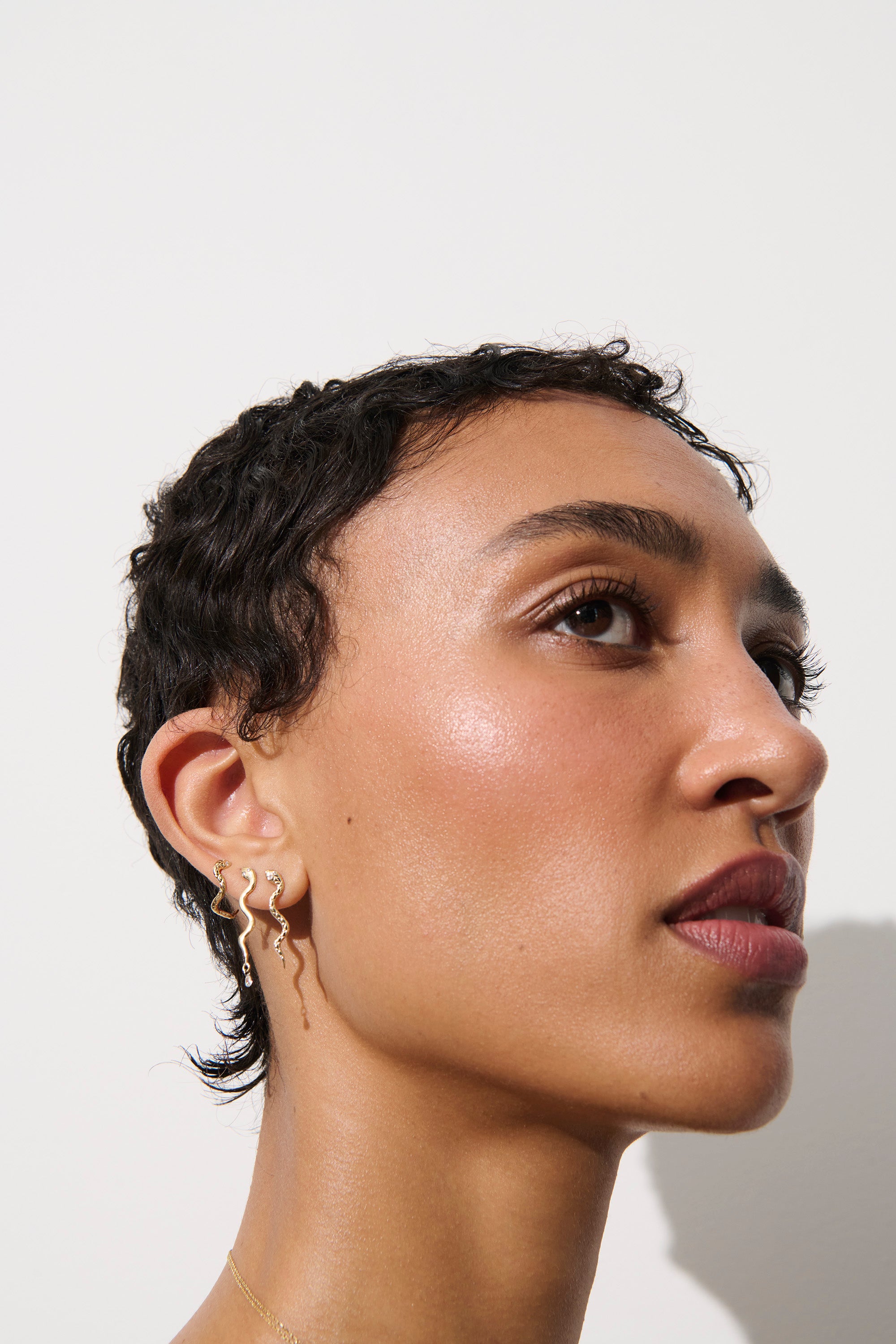 Alt="Vale Jewelry textured serpent half hoop earrings on model with serpent earrings with diamond drops and textured serpent earrings"