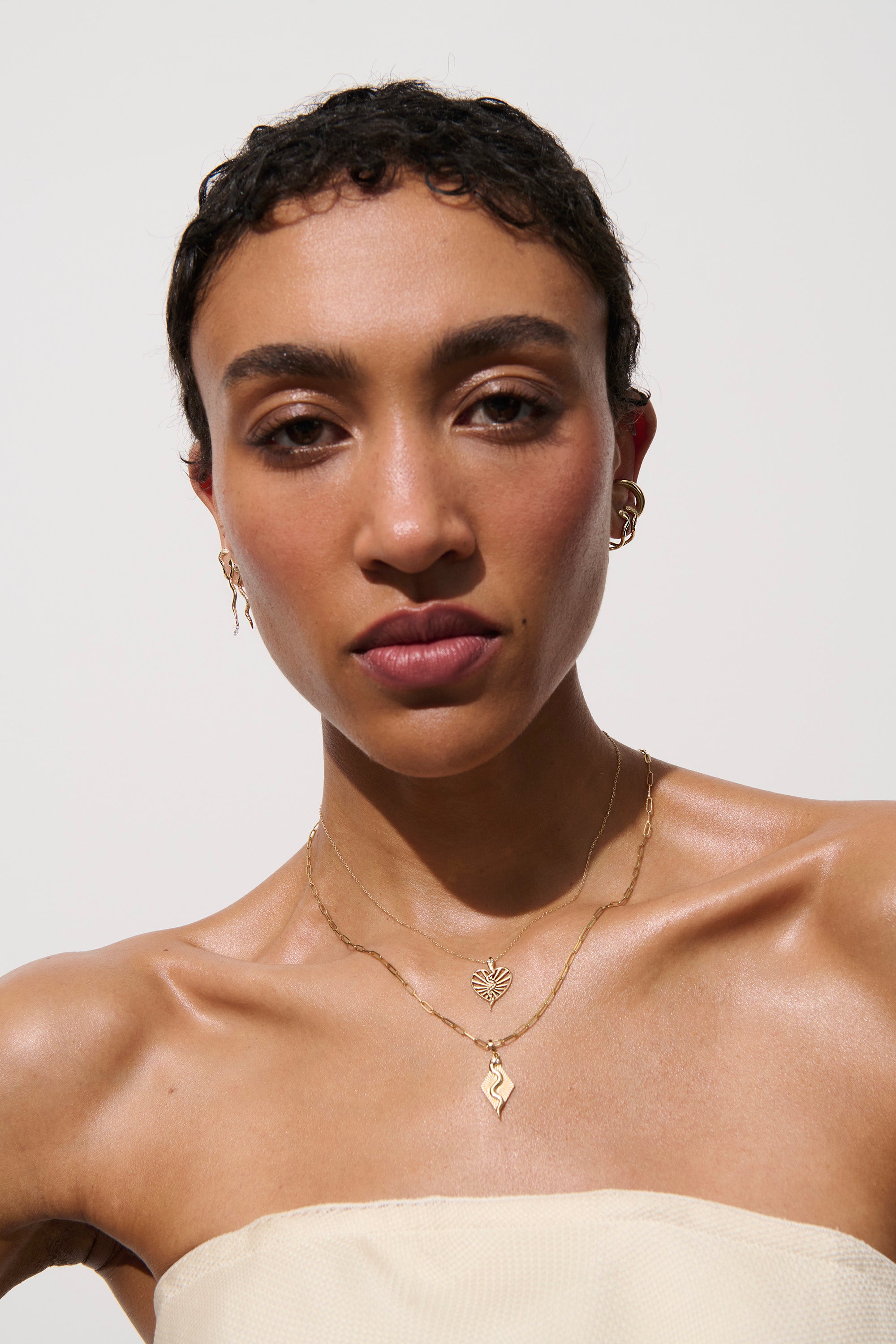 Alt="Vale Jewelry Textured serpent open ray heart necklace on model facing camera"