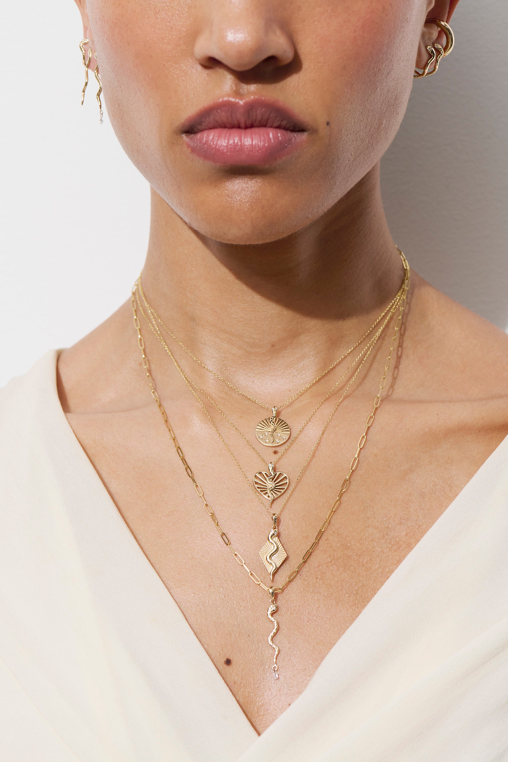 Model wearing serpent half ray disc necklace with other necklaces