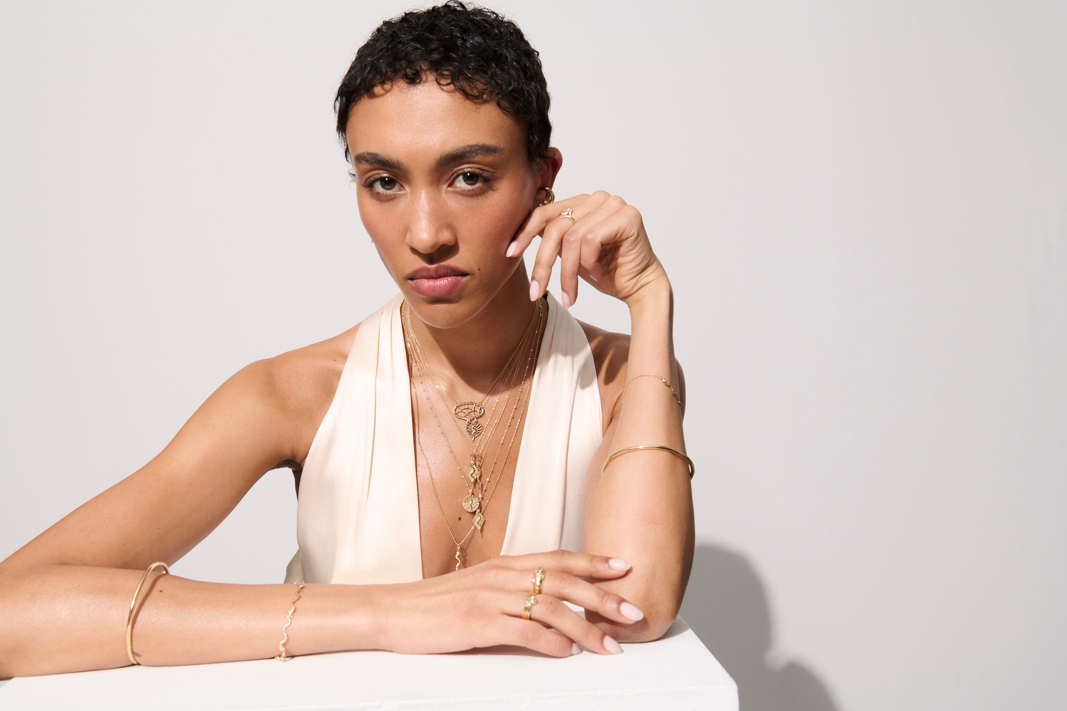 Alt="Vale Jewelry Model wearing web of stars necklace, serpent ray necklace, and other jewelry"